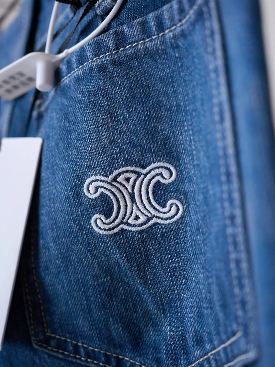 [Real auction] Celine/Celine Arc de Triomphe logo embroidered flared jeans (women's style) [In Stock] 30 31 32 Selected high-count cotton washed denim fabric, which has a warm and delicate touch, and is comfortable and close to the skin. Wearing a marine indigo base, natural water wash and smudged shades, warm Retro denim tones, and a relaxed and timeless Retro atmosphere. The large front patch pocket builds the Retro workwear heritage, and the back pocket is embellished with the White embroidered logo to create a visual ingenuity that is simple yet memorable. The neat mid-high waist and slightly flared trousers fit the waist and hips and spread out the pants smoothly, optimizing the leg lines, with just the right slight flare to create a slender and neat figure. Unlock a comfortable and elegant posture, allowing you to have unlimited dressing possibilities. 1. Imported machine embroidery technology uses advanced computer control systems and precision mechanical components to precisely create the iconic TRIOMPHE logo embroidery, with smooth and delicate lines and a full sense of sophistication. 2. Whole-strip denim scanning and spraying technology. The color of the entire jacket is partially faded through the washing process, and then put into the washing equipment for stripping, stone grinding and bleaching to show a uniform fading effect. The dye is sprayed on the entire denim fabric through a high-pressure pump to achieve the same color tone as the original. 3. Stone grinding for light fermentation➕stretching, bleaching and softening. The friction between the pumice stone and the clothes causes wear and fading effects on the surface of the denim. Through the combination of pulling and bleaching, the clothes are bleached while producing a certain texture and stretching effect, and a loose fit.